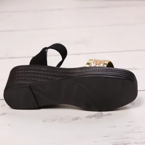 Detailansicht der Keilsandalette mit dicker Sohle und goldenem Glitzerriemen