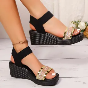 Detaillierte Nahaufnahme schwarzer Keilsandalen für Damen mit Glitzerriemen am Fuß