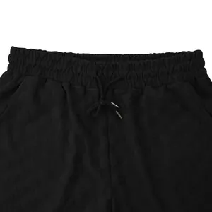 Detalle de los pantalones cortos negros para hombre con jacquard de cuadros y cintura elástica.