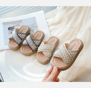 Detalle de elegantes sandalias para niñas decoradas con perlas y pedrería para el verano