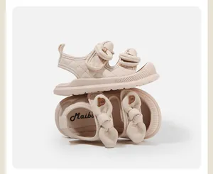 Primo piano di sandali beige per neonati con fiocchi decorativi e trama trapuntata