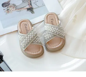 Detalle de chanclas de verano para niña con correas cruzadas de elegantes perlas y brillantes