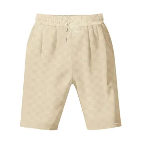 Detalle del tejido jacquard de cuadros beige en pantalones cortos de hombre