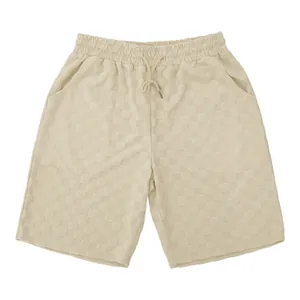 Vista detallada del pantalón corto beige de hombre con jacquard de cuadros.