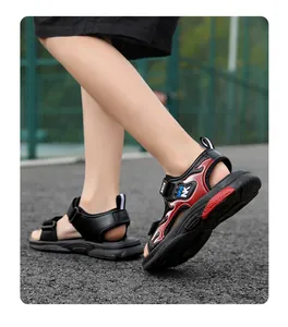 Niño pequeño con elegantes sandalias deportivas de exterior en negro y rojo sobre el pavimento