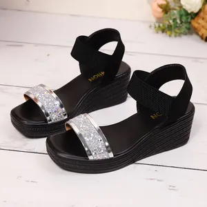 Seitenansicht von schwarzen Keilsandalen mit Glitzerriemen und elastischem Band