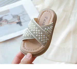 Detalle de sandalias elegantes para niña con perlas de imitación y strass brillante