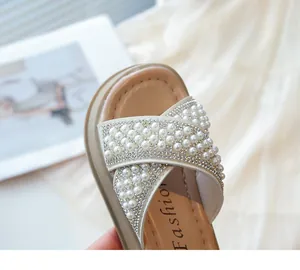 Detalle de cerca de las sandalias de verano para niña con perlas y diamantes de imitación