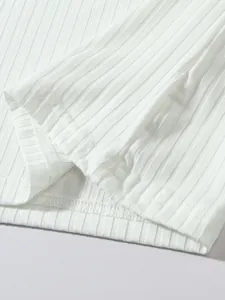 Detailed close-up of white ribbed knit fabric showing high-quality stitching and texture