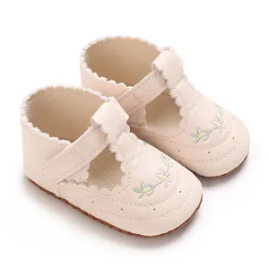Detail van crème babyschoentjes Mary Jane voor meisjes met bloemenborduursel en rand