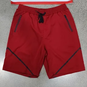 Detailansicht der roten Herren-Sportshorts mit Reißverschlusstaschen und Kordelzug