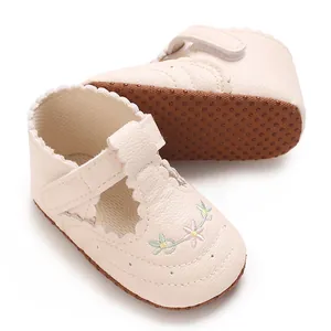 Close-up van crème babyschoentjes voor meisjes met bloemborduurwerk en antislipzool