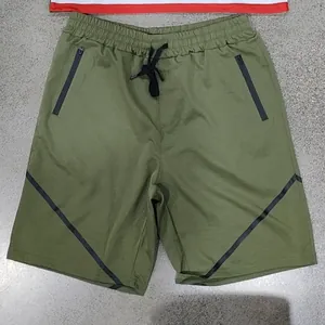 Detaillierte Nahaufnahme der olivgrünen Herren-Sportshorts mit schwarzen Reißverschlusstaschen