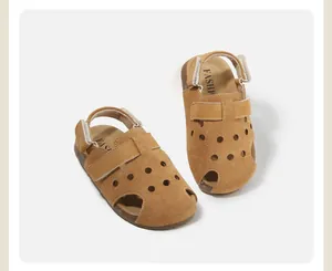 Detalle de sandalias infantiles de ante marrón con puntera cerrada y perforaciones