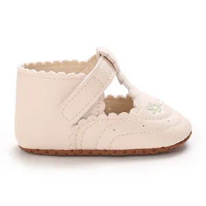 Zijaanzicht van beige baby meisje loopschoenen met geborduurde bloem en geschulpte rand