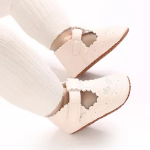 Detailweergave van crème babyprinsesschoentjes met borduursel en geschulpte randen.