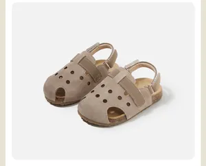 Primer plano de sandalias de ante beige para niños con diseño calado transpirable