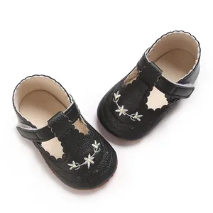 Detailweergave van zwarte babyschoentjes voor meisjes met geborduurde bloemen en een zachte zool