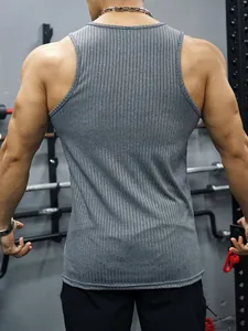 Back view of men's gray ribbed slim-fit fitness tank top in gym