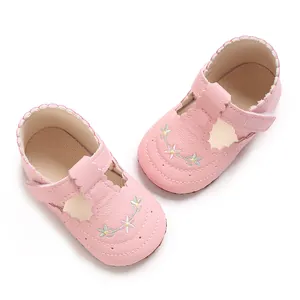 Detailopname van roze babyschoentjes voor meisjes met bloemenborduursel en zachte zool.