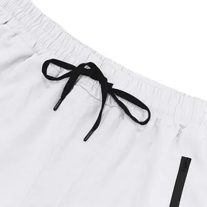 Primo piano di pantaloncini sportivi bianchi con coulisse nera e tasca con zip