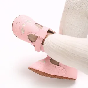 Detail van roze baby loopschoenen met bloemenborduurwerk en zachte zool voor meisjes