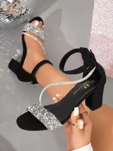 Close-up of black chunky heel sandals with sparkling silver rhinestone straps