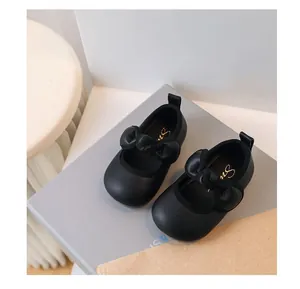 Close-up shot of black baby girl princess shoes featuring soft soles and cute bows