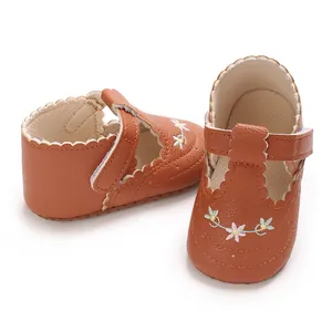 Close-up van bruine prinsessenschoenen voor baby's met bloemenborduurwerk