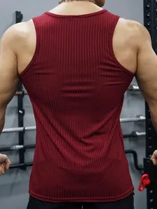 Close-up back view of men's burgundy ribbed slim fit gym tank top in a fitness gym