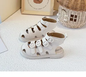 Close-up view of elegant white closed-toe baby sandals with triple strap velcro design