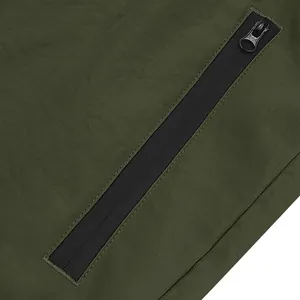 Dettaglio della tasca con cerniera impermeabile sui pantaloncini sportivi verde oliva