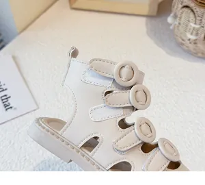 Macro detail view of beige baby Roman sandals featuring secure buckles and velcro straps