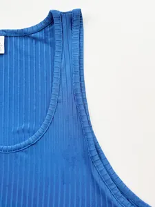 Gros plan du débardeur en maille côtelée bleue montrant le col et les coutures d'épaule