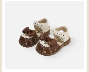 Close-up detail of stylish toddler girl sandals with brown bow and star patterns