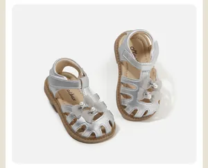 Detaillierte Ansicht der silbernen Mädchensandalen mit eleganten Schleifen- und Perlenakzenten