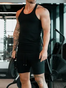 Vue détaillée d'un débardeur de sport noir côtelé pour homme dans une salle de sport
