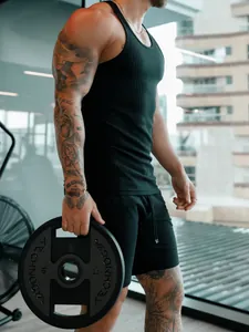 Gros plan d'un débardeur de sport noir pour homme montrant sa coupe ajustée et son tissu