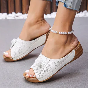 Sandales compensées blanches élégantes avec fleur et motifs découpés au laser sur modèle
