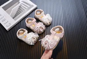Elegant pink and beige baby girl princess sandals with pearl bow and soft soles.