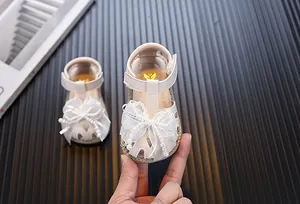 Detail view of baby girl princess sandals featuring a large pearl mesh bow