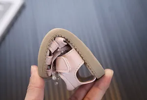 Close-up showing the extremely soft and flexible rubber sole of the pink baby pearl sandals
