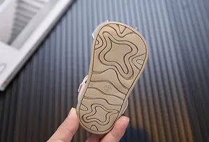 Macro view showing the anti-slip wavy texture on the soft sole of baby walking shoes
