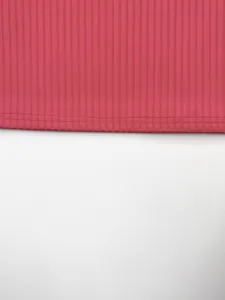 Détail de la couture de l'ourlet et du tissu en maille côtelée rose du débardeur homme