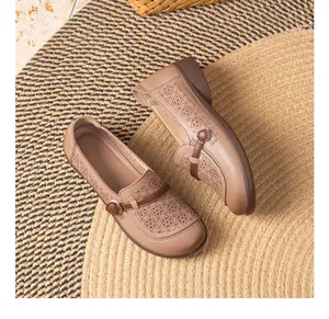 Detailed view of breathable floral hollow-out pattern on beige leather comfort flats