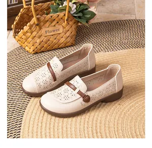 Detail view of beige hollow-out soft-soled mother shoes with elegant floral patterns