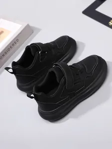 Détail de baskets noires pour garçons à semelles épaisses avec velcro et finition cuir