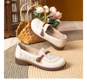 Detailed view of cream perforated loafers with geometric patterns and soft sole