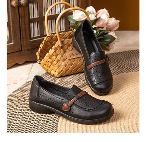 Close-up detail of breathable hollow-out black leather loafers for senior women