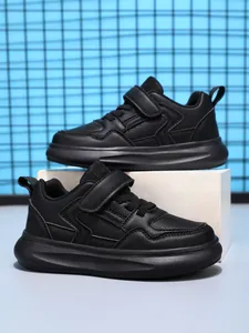 Vue détaillée des baskets en cuir à plateforme pour enfants noires sur un support